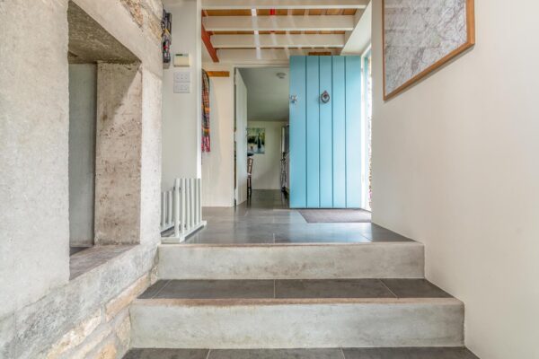 Interior of The Garden House at The Malthouse in Norton St Philip. Steps leading up to the main door with kitchen in background