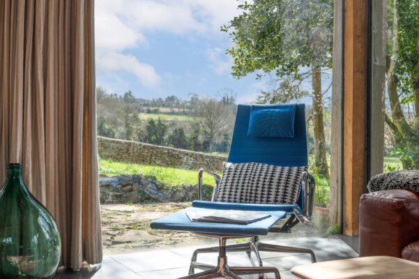 A retro blue chair located by a large window with countryside views at The Garden House in Norton St Philip